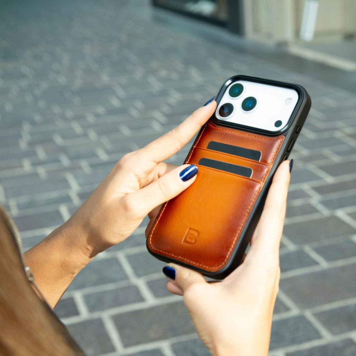 Valentine’s Day iPhone 17 leather case with card holder in hand, genuine leather phone case outdoors