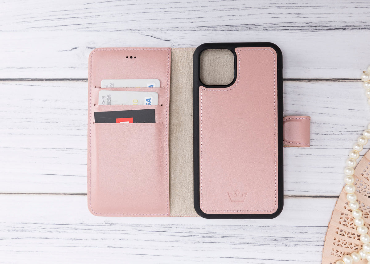 Pink phone wallet case with card slots on a light wooden surface