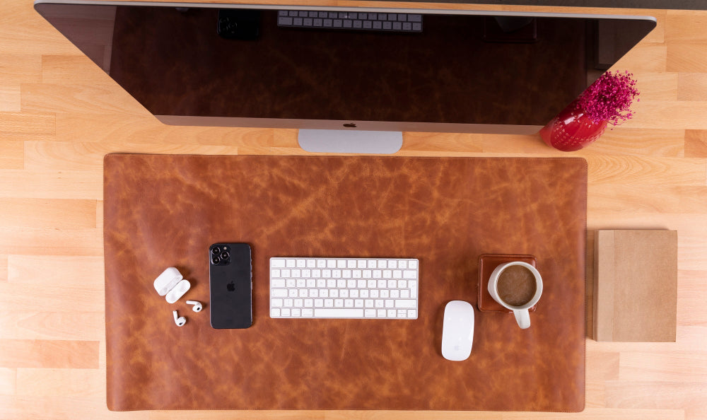 Top view of a desk with a computer setup including a monitor, keyboard, mouse, and coffee cup.