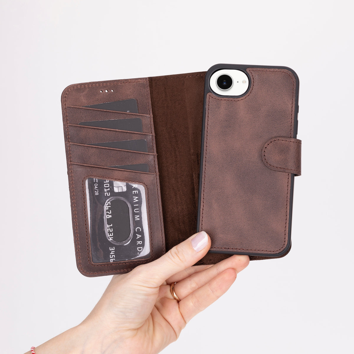 Brown leather phone wallet with card slots held by a hand on a light gray background