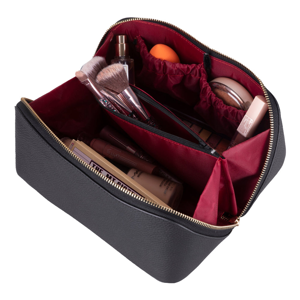 Black makeup bag with red interior containing cosmetic items on a white background