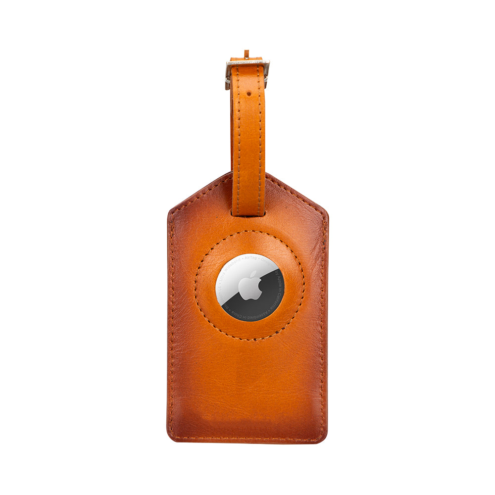 Brown leather luggage tag with a circular metallic emblem on a white background
