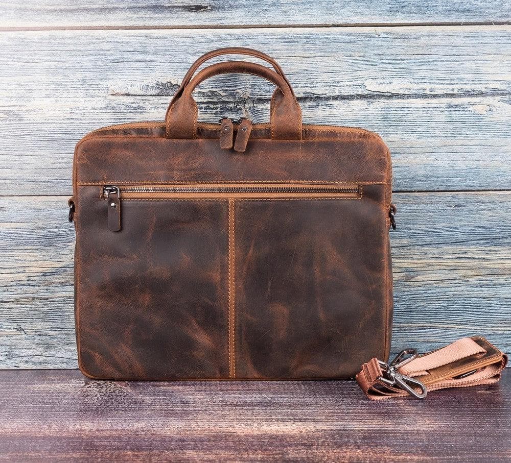 Brown leather briefcase with matching keychain on a wooden surface
