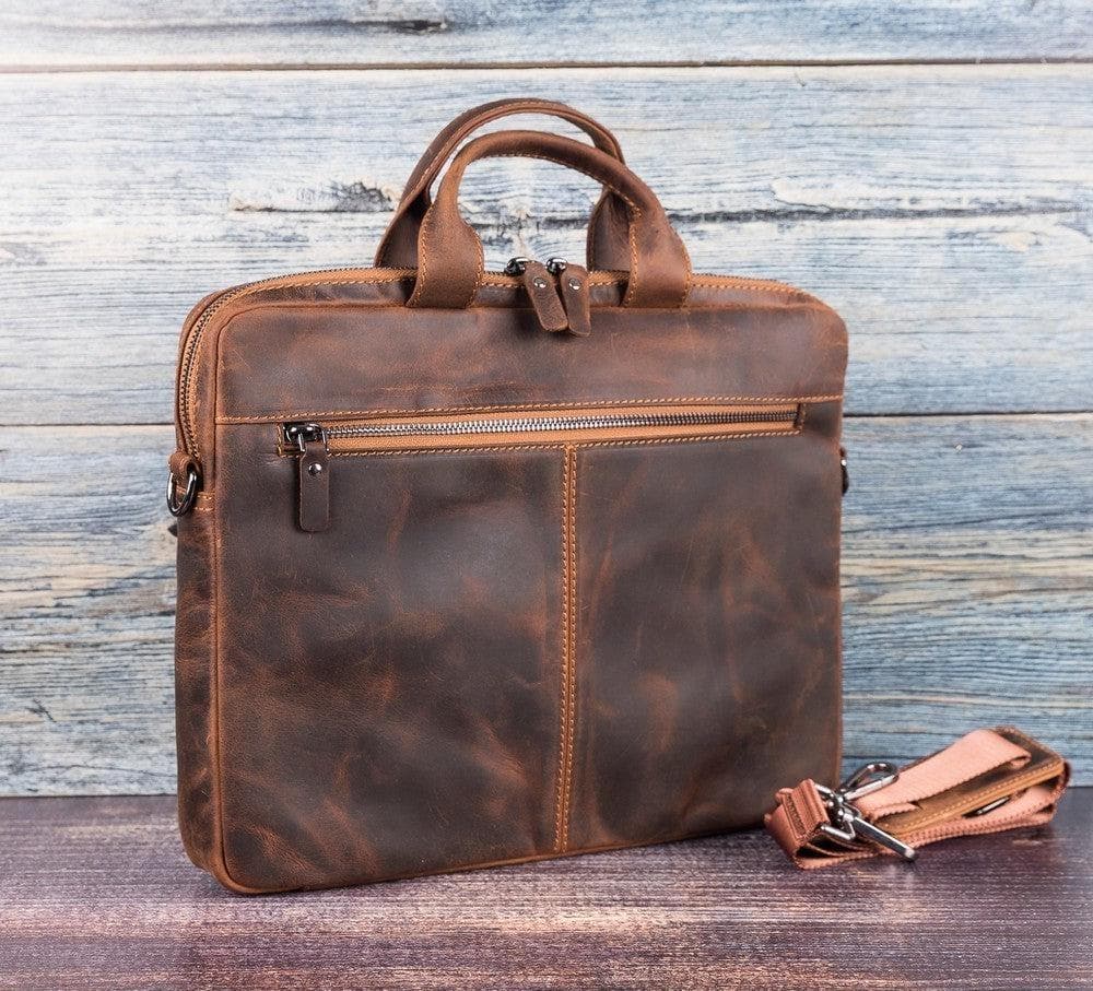 Brown leather briefcase with a strap on a wooden surface and rustic wooden background