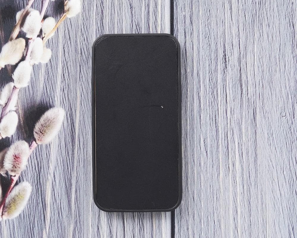 Black smartphone on a wooden surface with floral elements