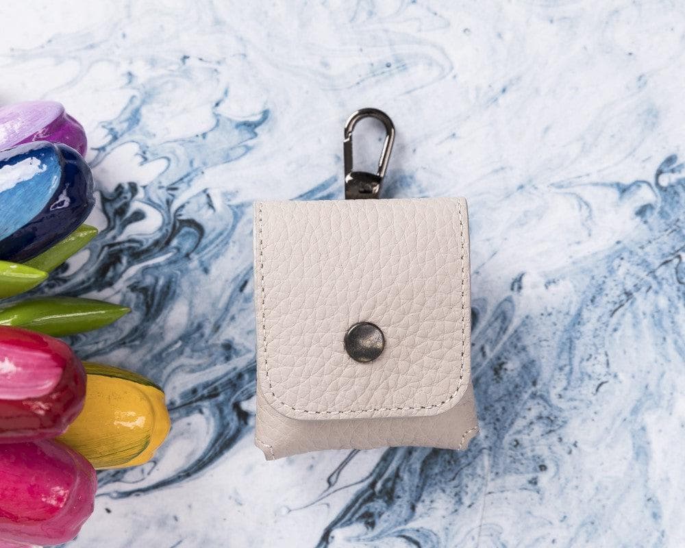 Small beige leather pouch with a clasp on a marble surface