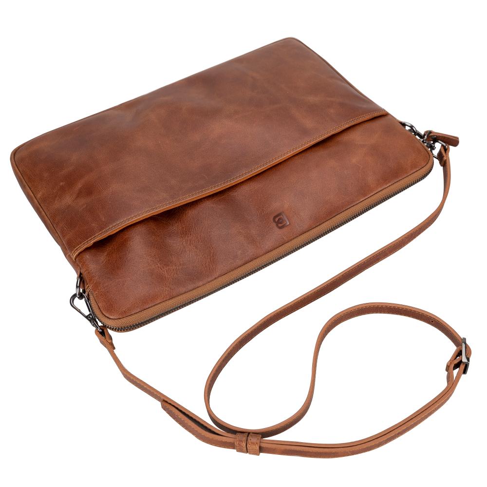 A brown leather laptop/tablet sleeve with a soft suede lining, featuring a secure zipper closure, an adjustable shoulder strap, and a back handle for easy carrying.