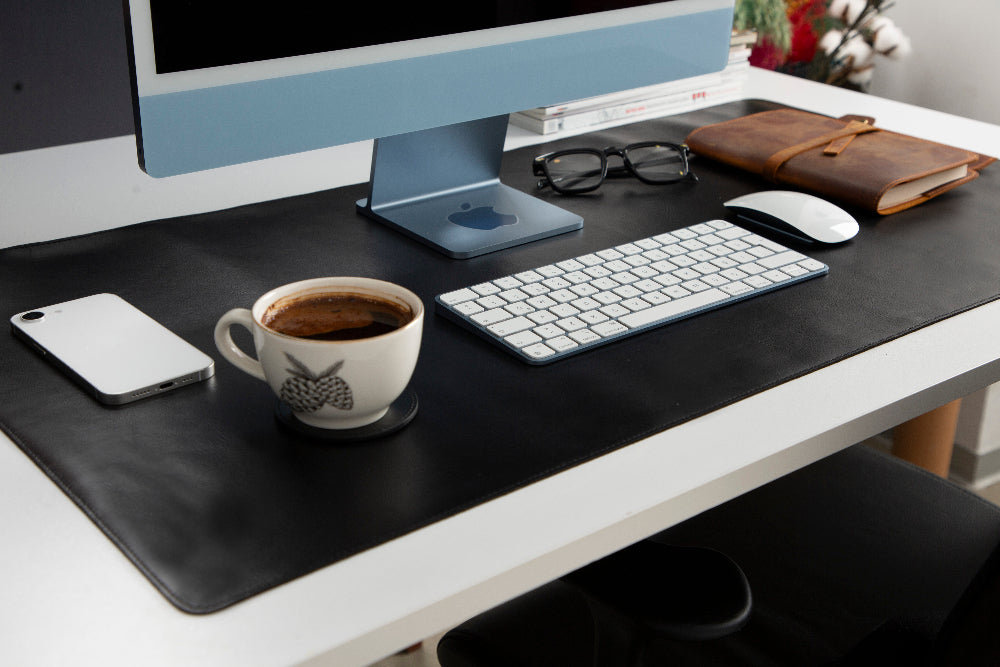 Modern office desk setup with computer, phone, coffee cup, and accessories.