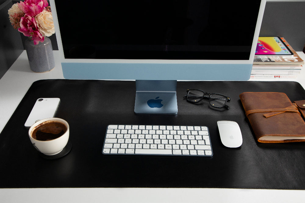 Modern office desk setup with computer, keyboard, mouse, and other items.