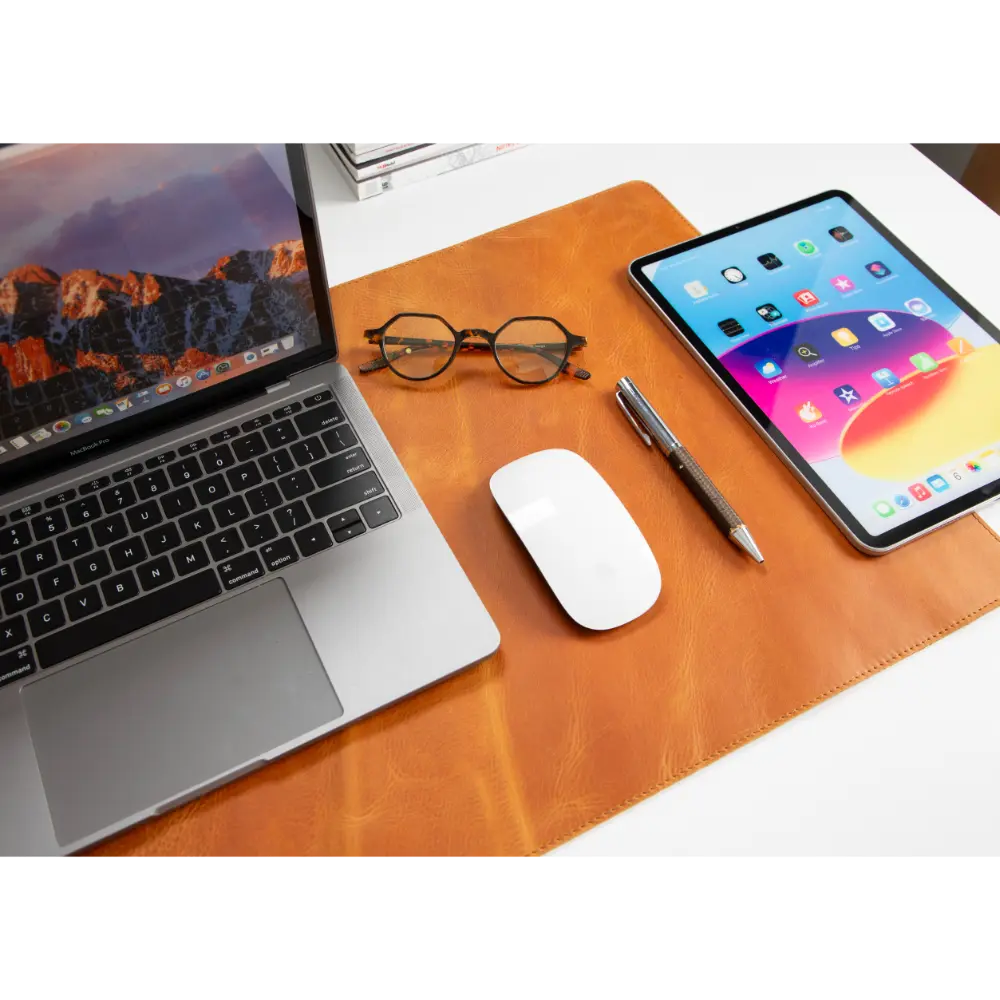 Laptop, tablet, mouse, and pen on a wooden desk