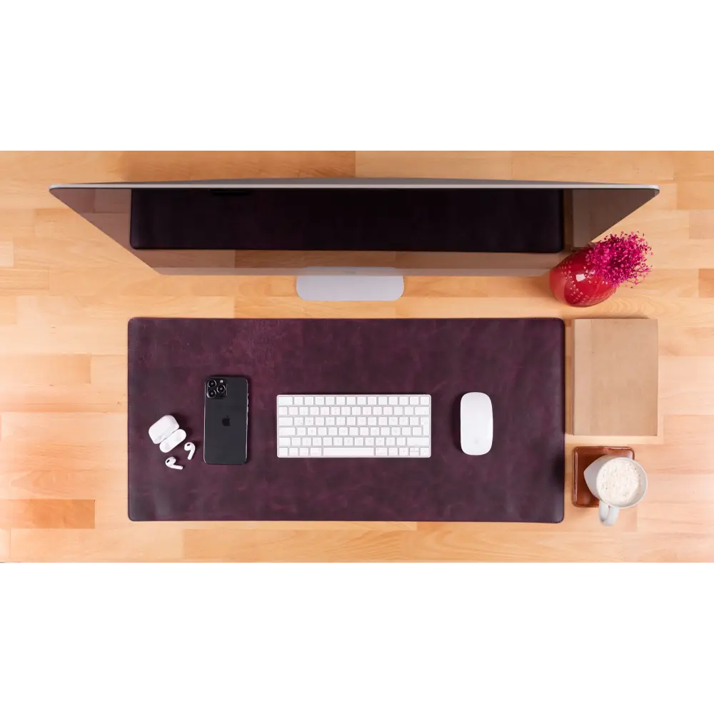 Wooden desk with computer monitor, keyboard, mouse, phone, and mug on a white background