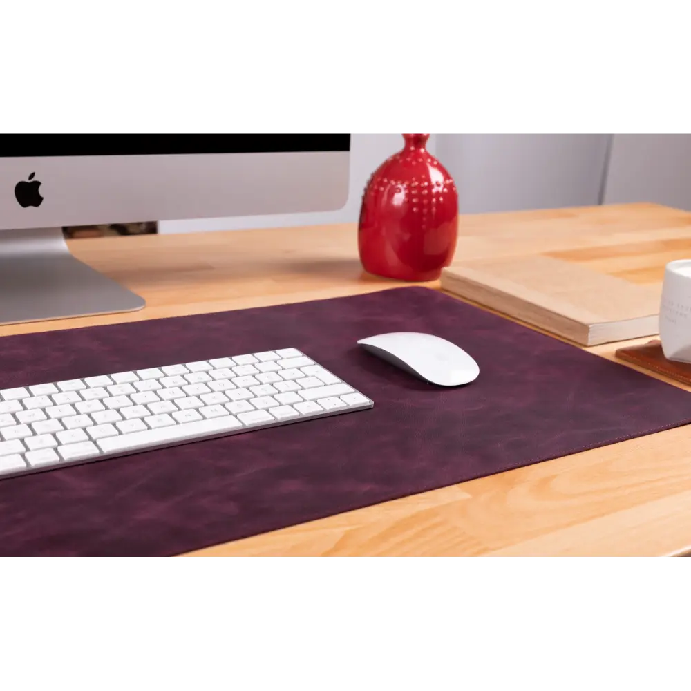 Desk setup with computer, keyboard, mouse, and decorative items on a wooden desk.