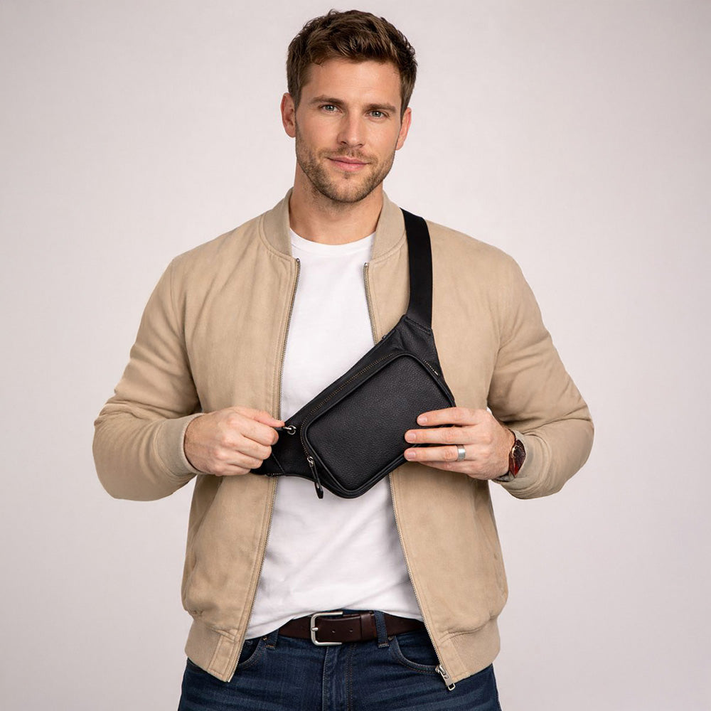 Man holding a black waist bag against a plain background