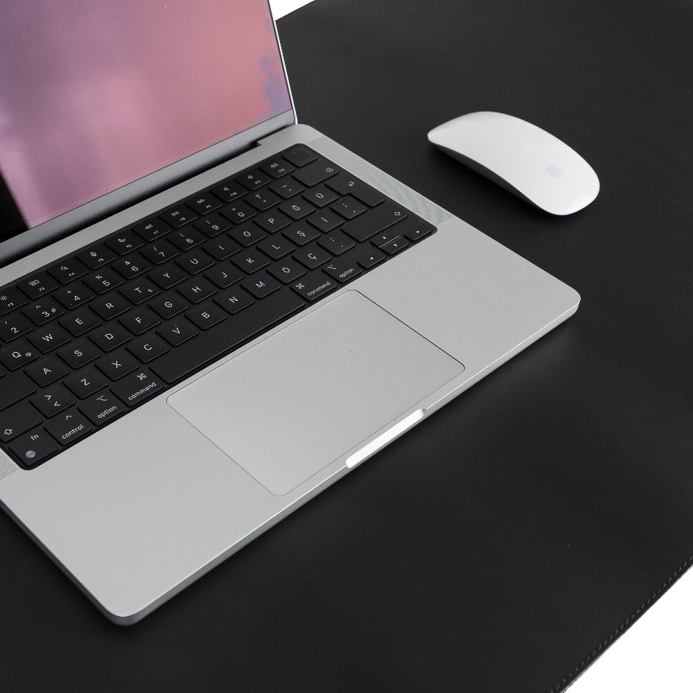 Laptop with black keyboard and white mouse on a dark surface