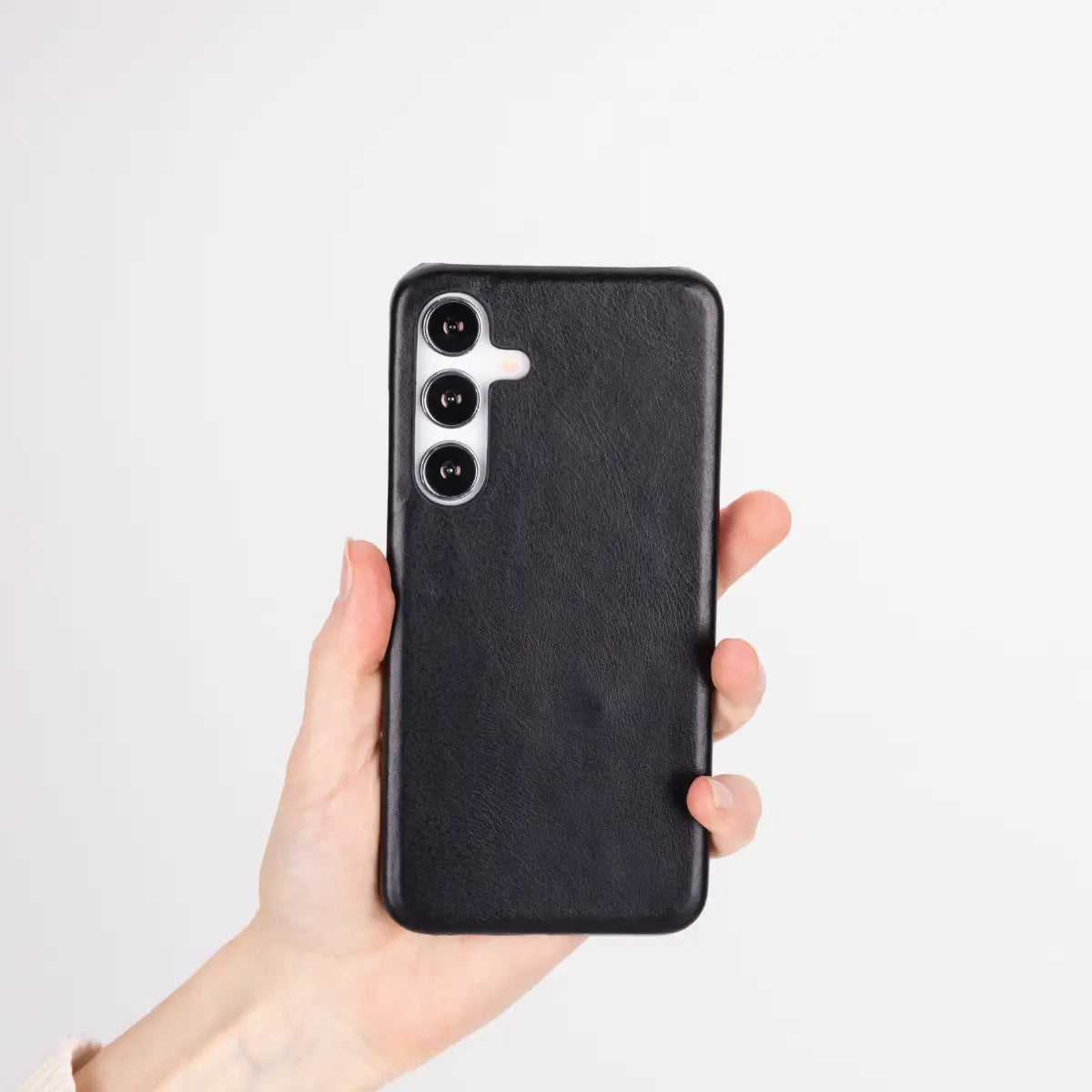 Black phone case held by a hand on a light gray background