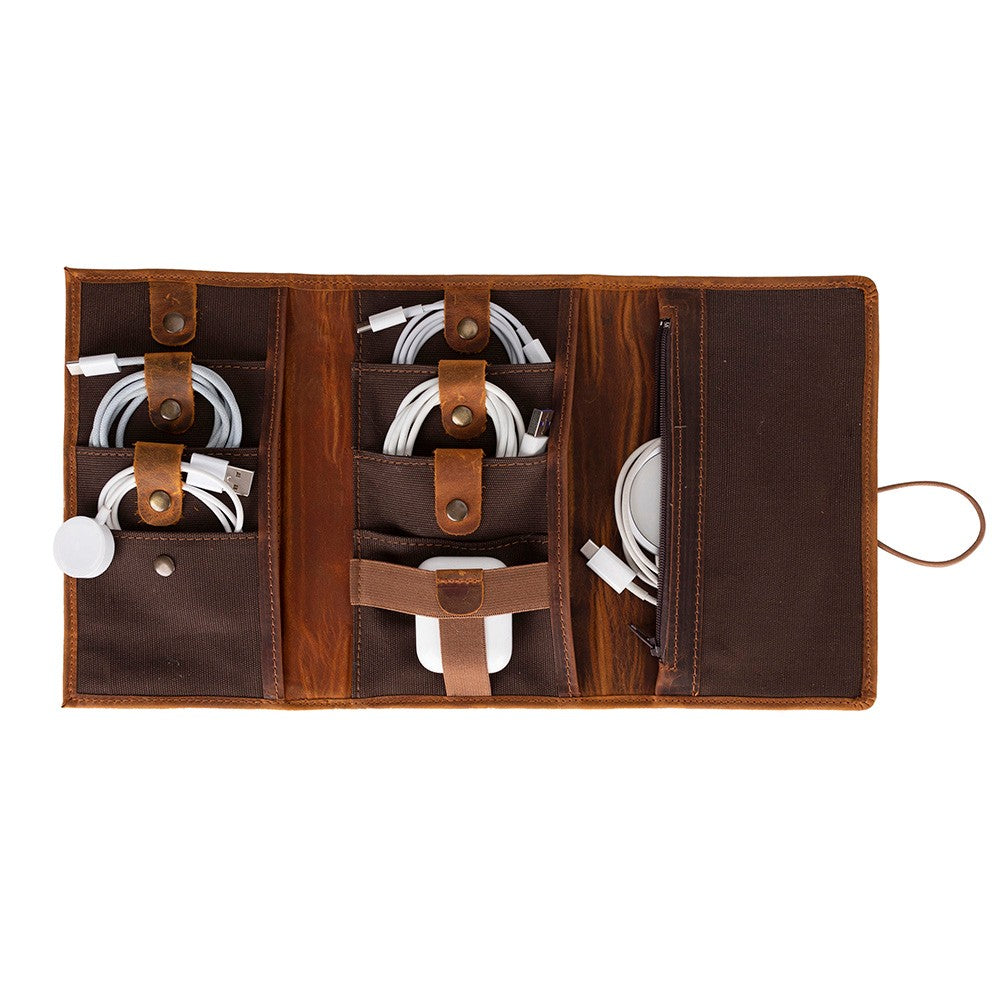 Brown leather cable organizer with multiple compartments on a white background