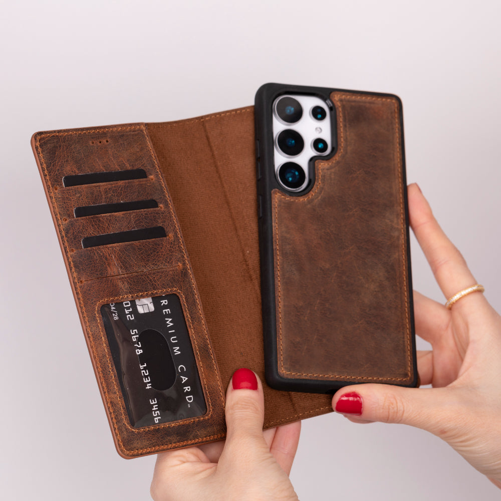 Brown leather phone case with card slots held by a hand on a light gray background