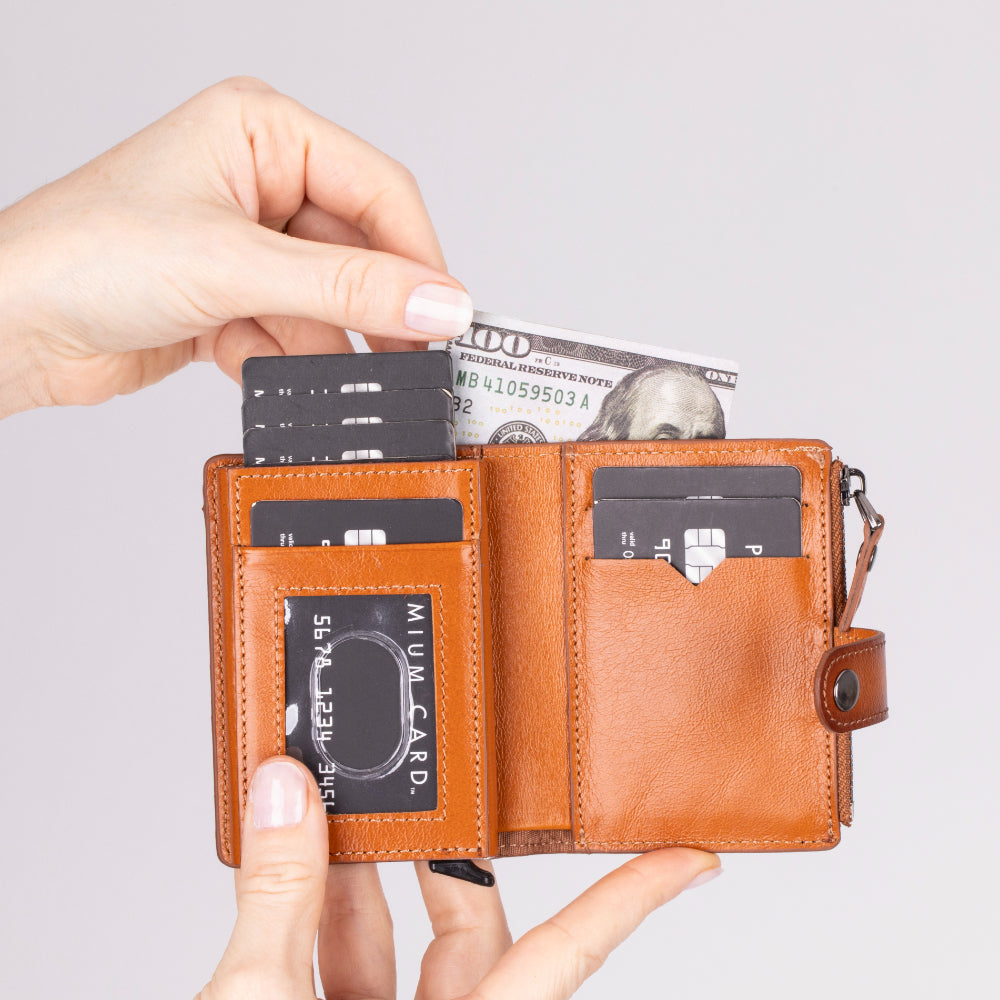 Brown leather wallet with cards and money on a light gray background