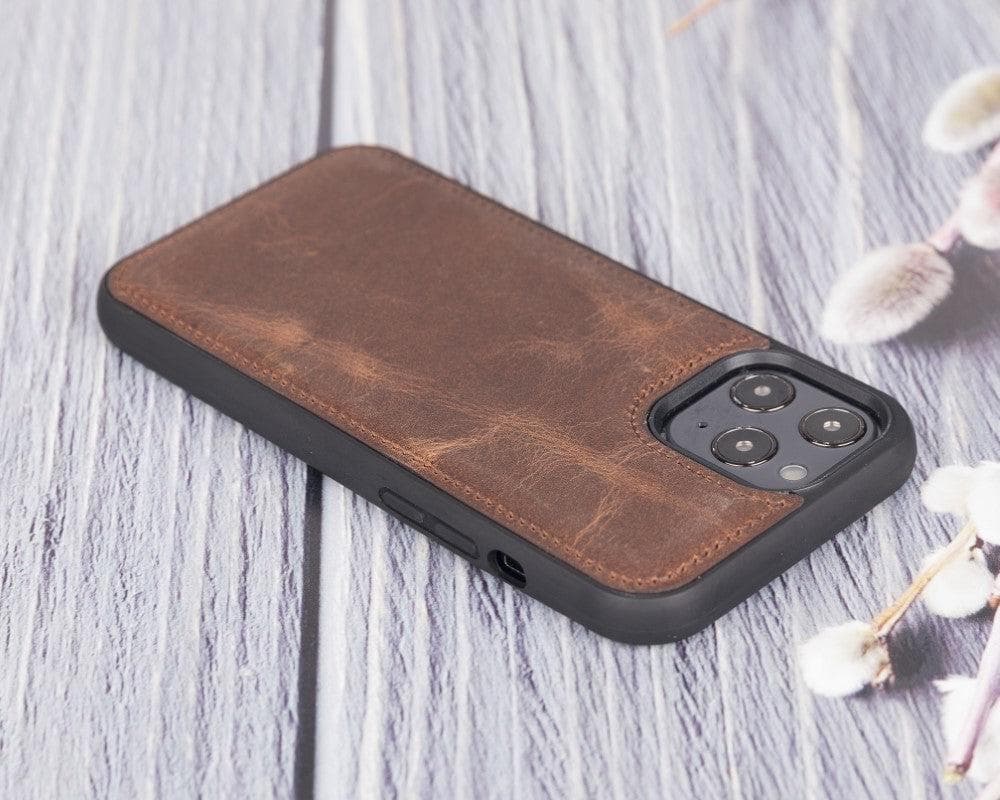 Brown leather phone case on a gray wooden surface with floral decorations