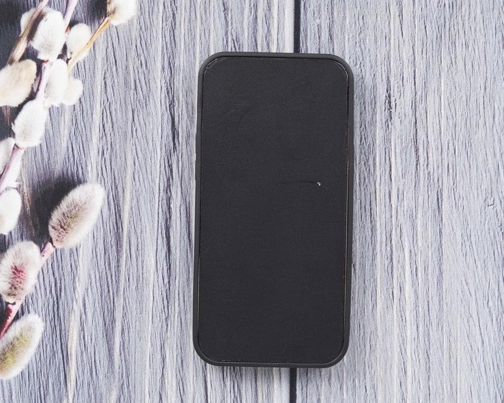 Black rectangular object on a gray wooden surface with floral decorations.
