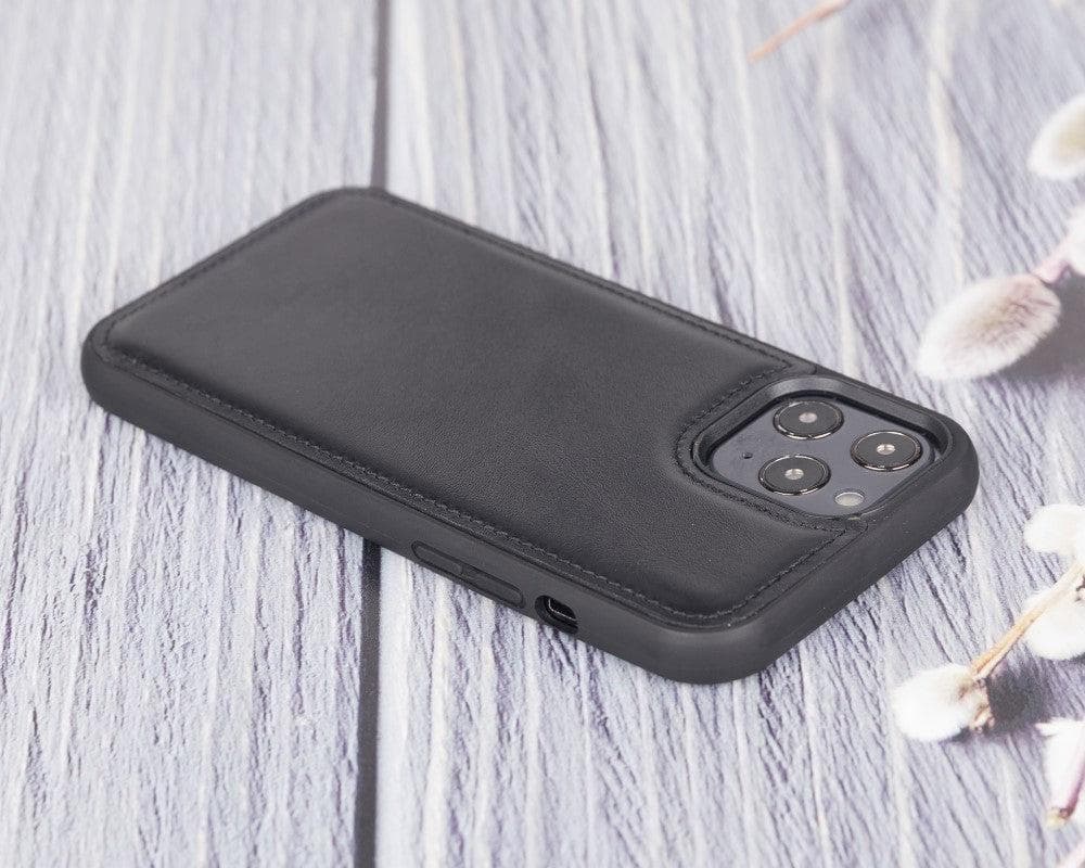 Black phone case on a light wooden surface with floral decorations