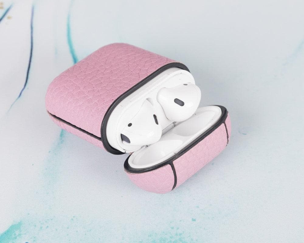 Pink wireless earbud case with white earbuds on a light blue textured background