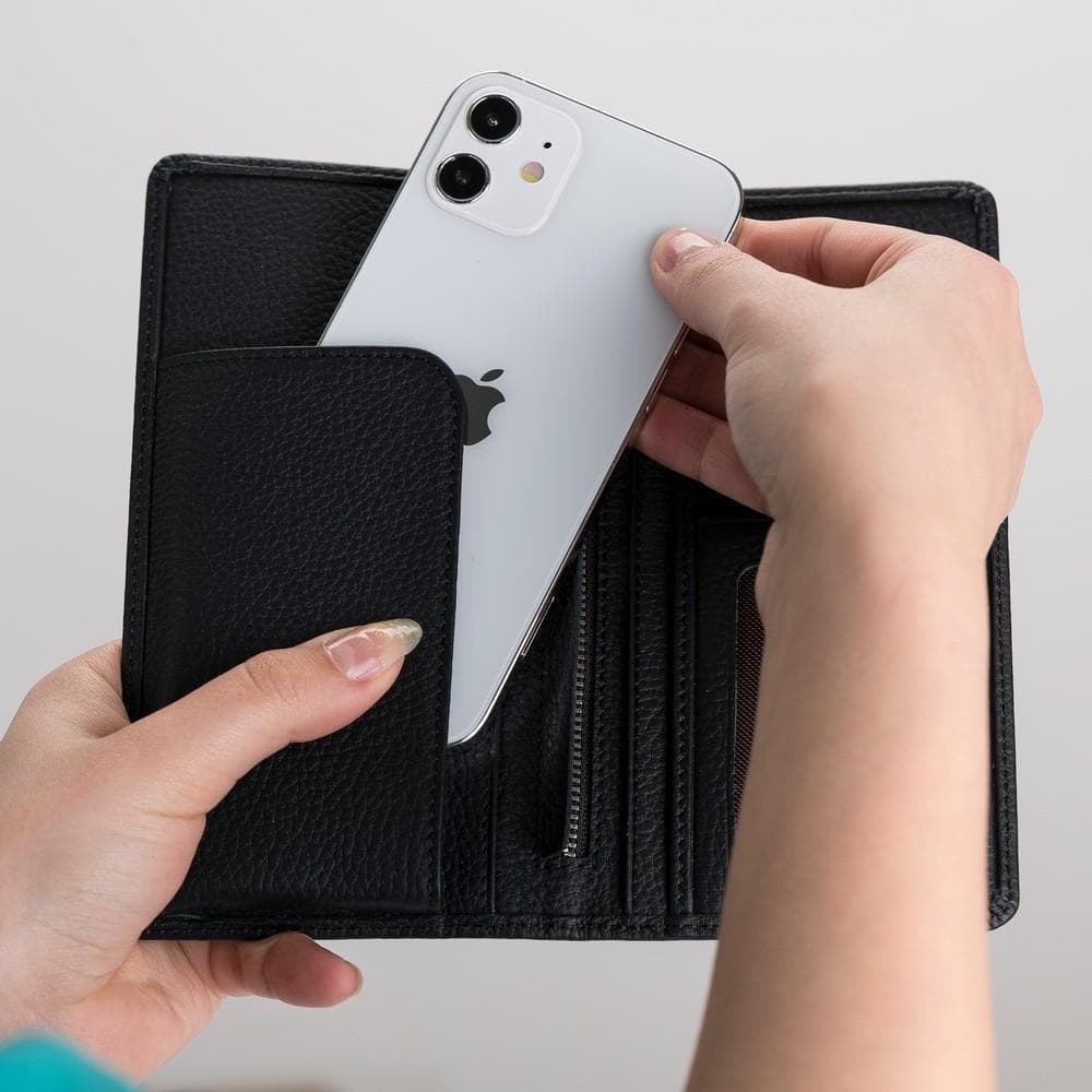 Person holding a black wallet with a phone inside against a light gray background